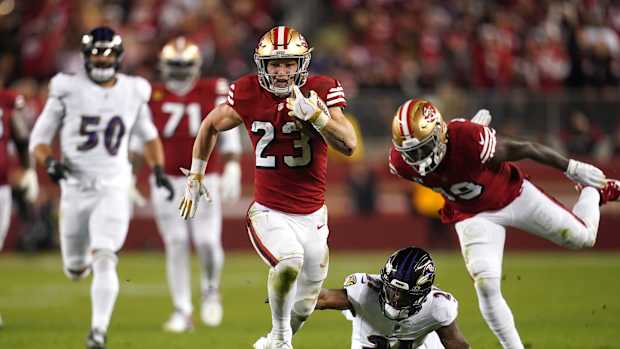 Dec 25, 2023; Santa Clara, California, USA; San Francisco 49ers running back Christian McCaffrey (23) runs the ball pressured by Baltimore Ravens cornerback Brandon Stephens (21) in the second quarter at Levi's Stadium. Mandatory Credit: Cary Edmondson-USA TODAY Sports  